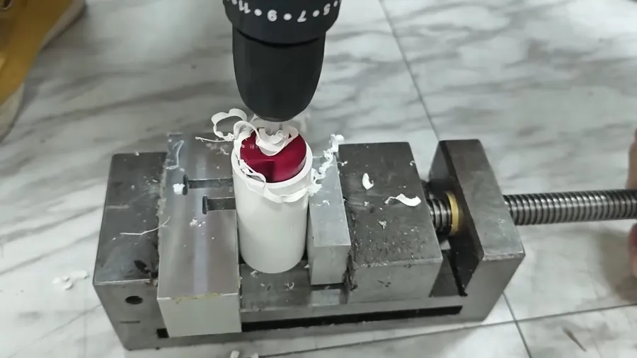 Drill pressing a plastic pipe fitting during repiping for Plumbing Services in Lakewood, CA