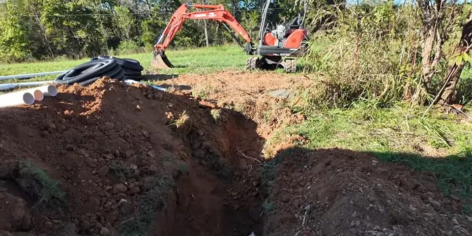Excavated yard trench with heavy equipment nearby for Plumbing Service in the Del Amo Boulevard Corridor, Lakewood CA