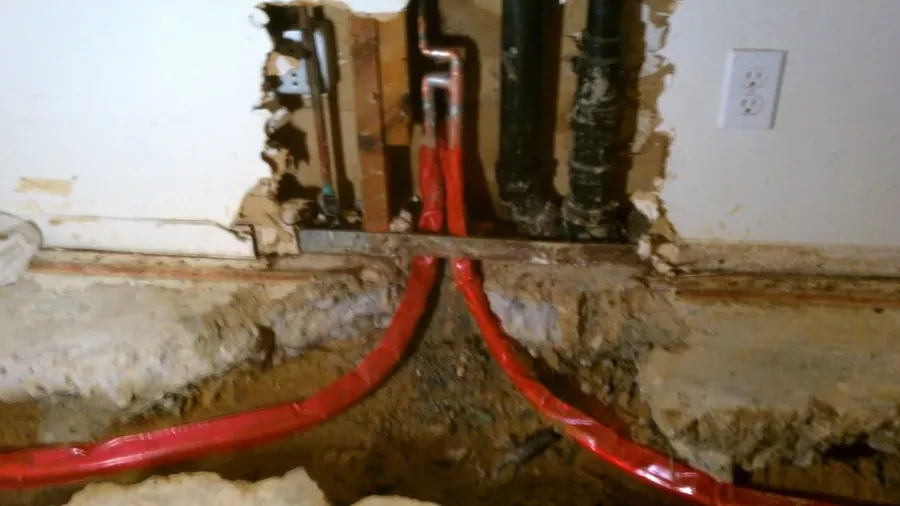 New red and blue PEX lines routed through an open wall for Repiping & Whole-Home Pipe Replacement in Lakewood, CA