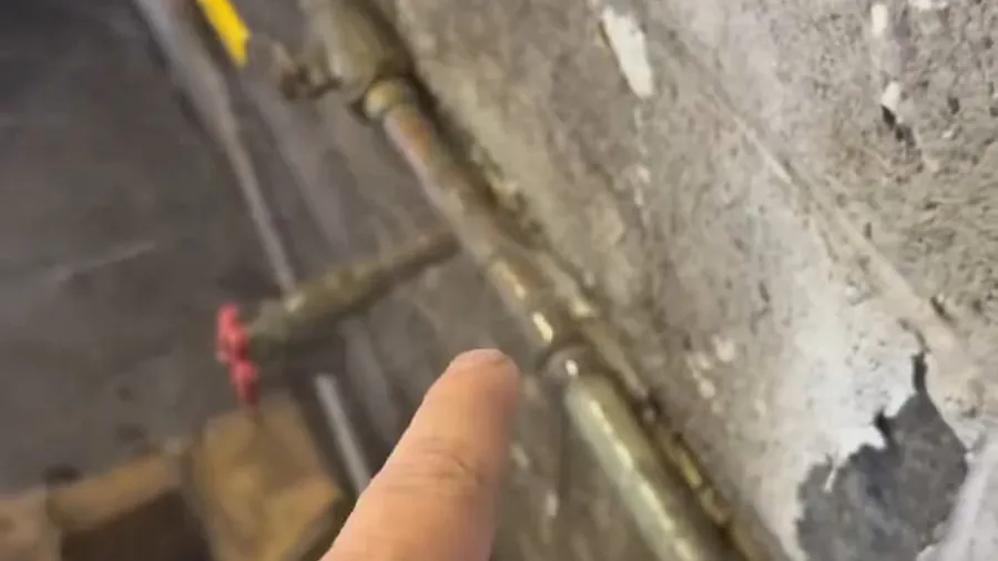Open wall showing old water line repair access for About Lakewood CA Plumbing Guys