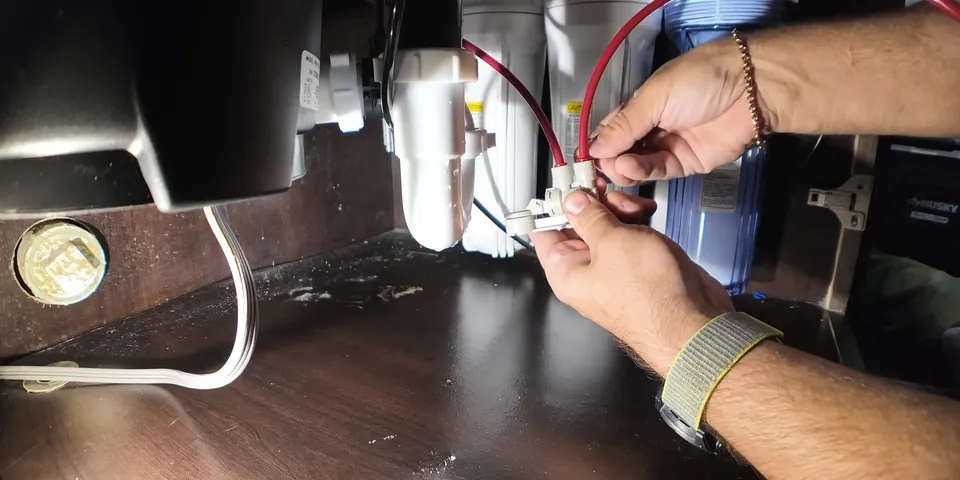 Supply tubing being connected under a sink filtration system for Water Filtration Installation in Lakewood, CA