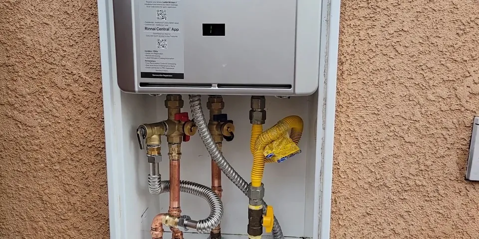 Tankless water heater mounted on an exterior wall for Water Heater Replacement in Lakewood, CA: Tank, Tankless, and California Rules