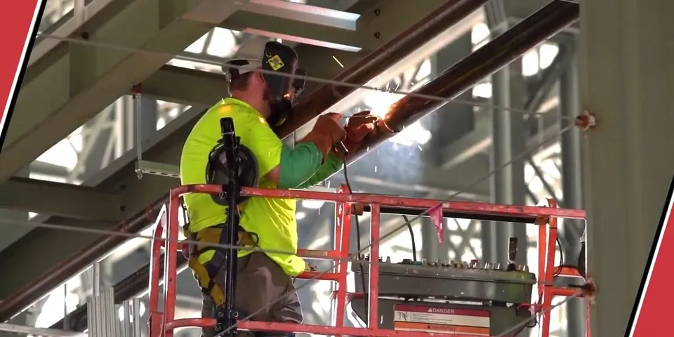 Technician working on elevated commercial plumbing supports for Plumber in Carson, CA
